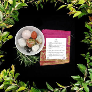 Elegant display of the Pregnancy Tumbles crystal set from Crystal Visions, featuring healing crystals in a stylish pouch, surrounded by lush greenery, emphasizing luxury for expecting mothers.